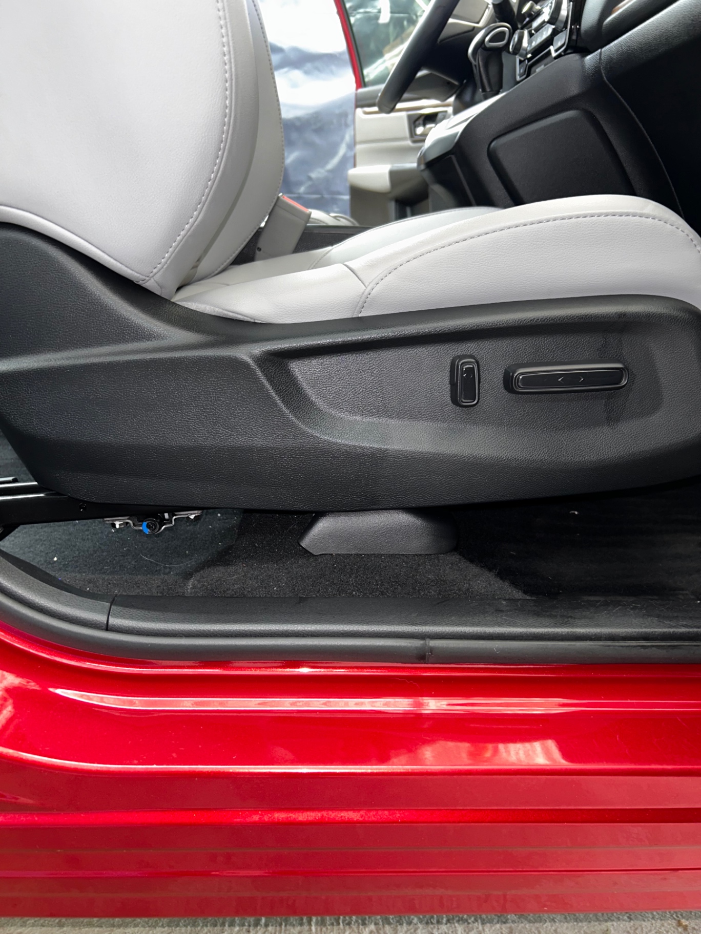 Detailed door sill, seat base and carpet on a red SUV