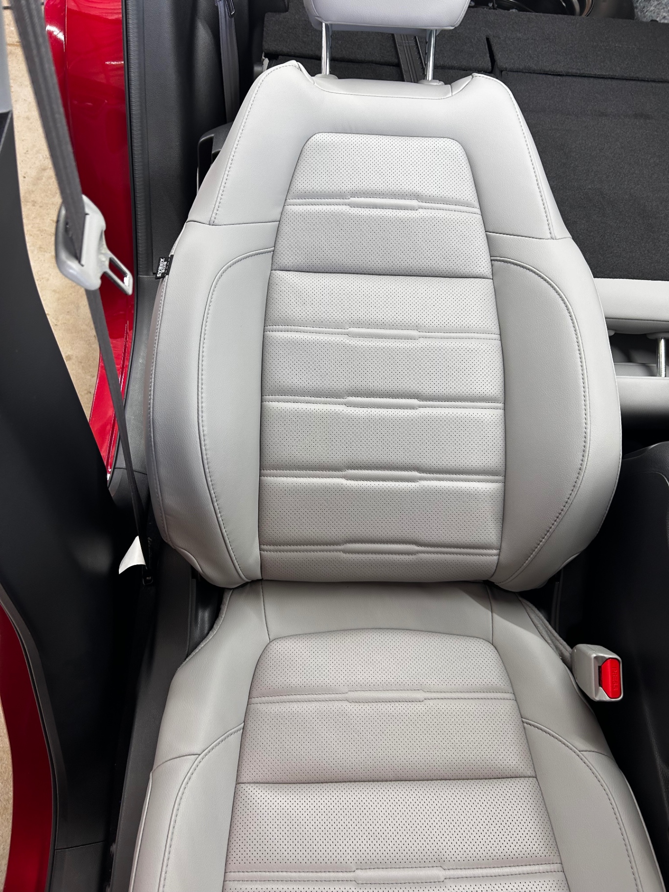 Cleaned and conditioned grey perforated leather seat