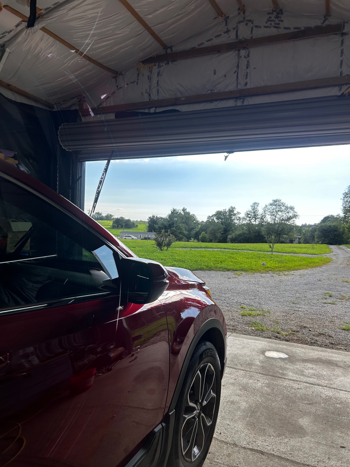 Detailed red SUV finished and pulled out of the shop bay