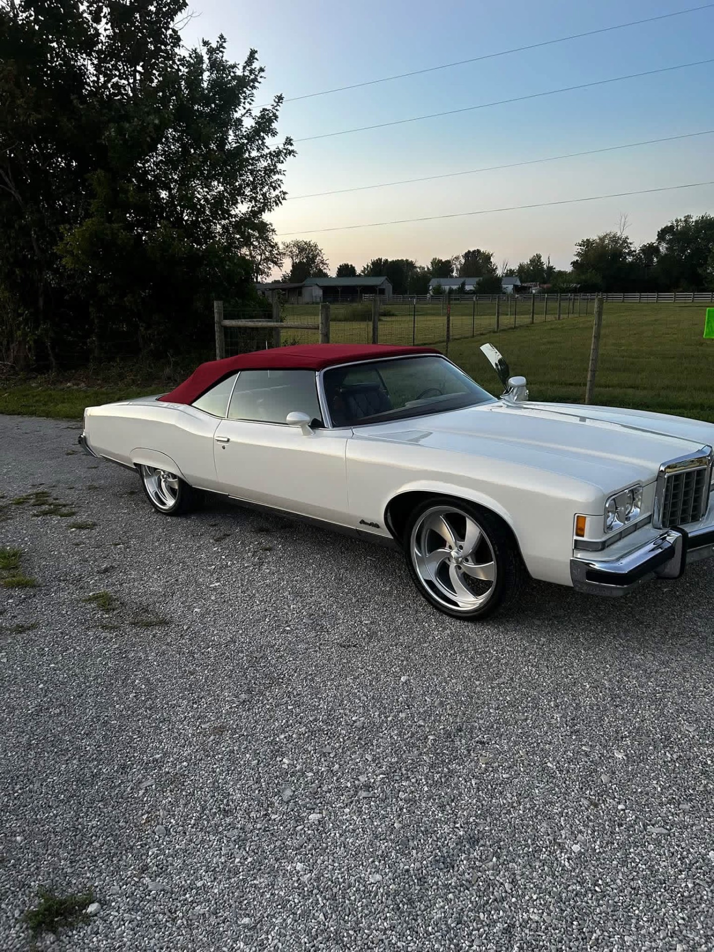 White classic convertible with red top detailed and parked on gravel