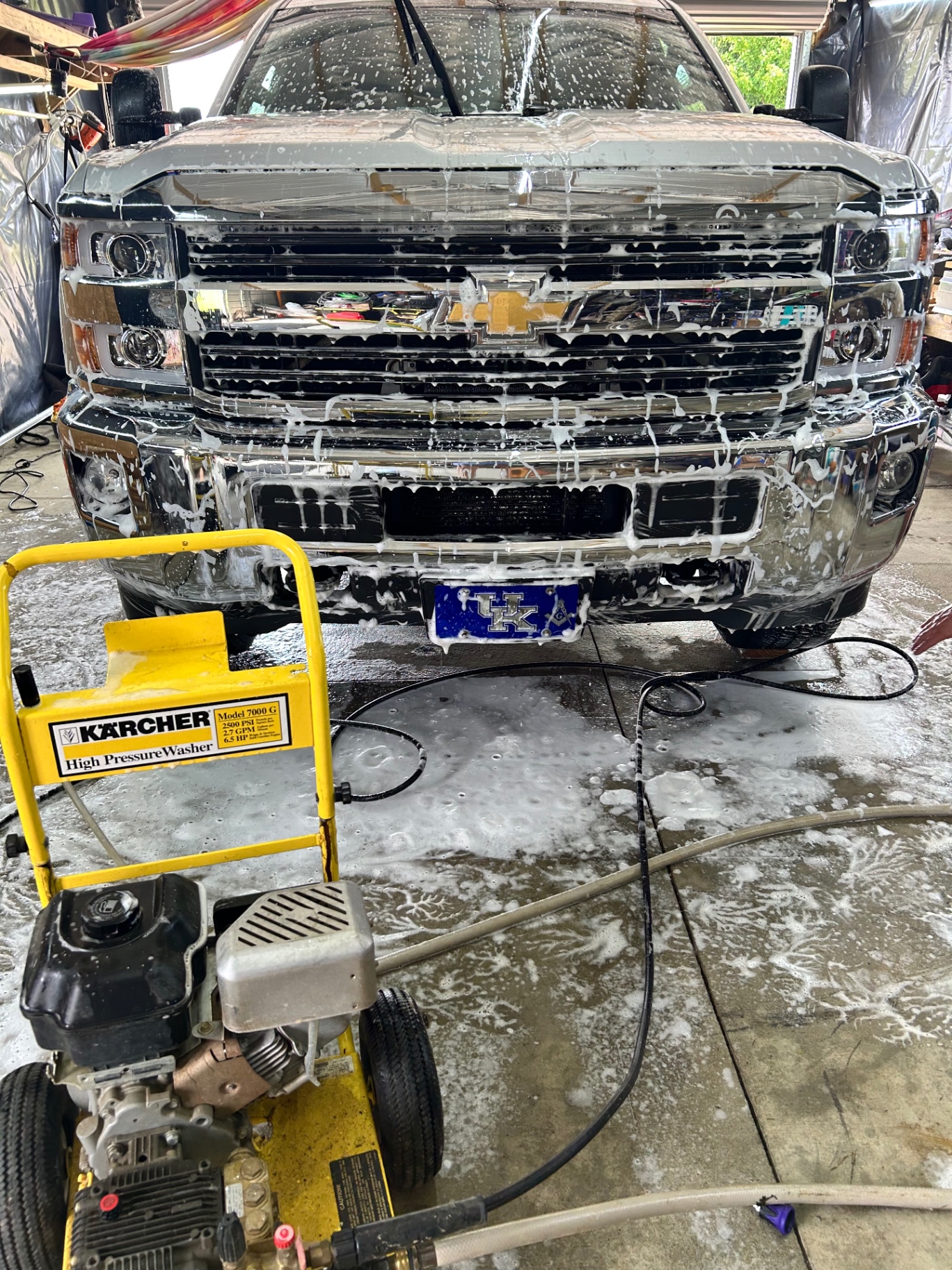 Chevrolet Silverado covered in wash foam in a detailing bay