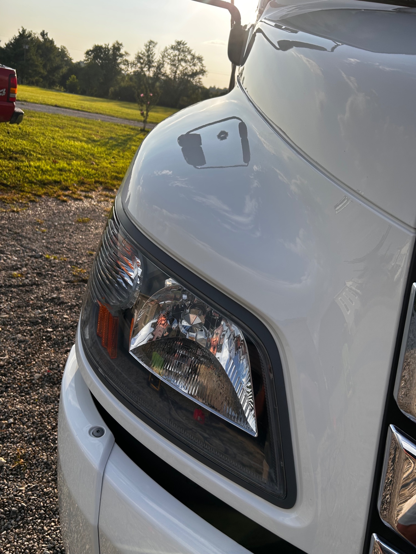 Close-up of a corrected, glossy white truck hood and headlight