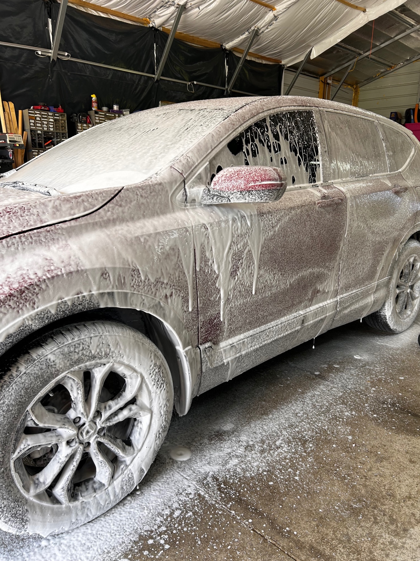 SUV covered in thick snow foam during the wash stage