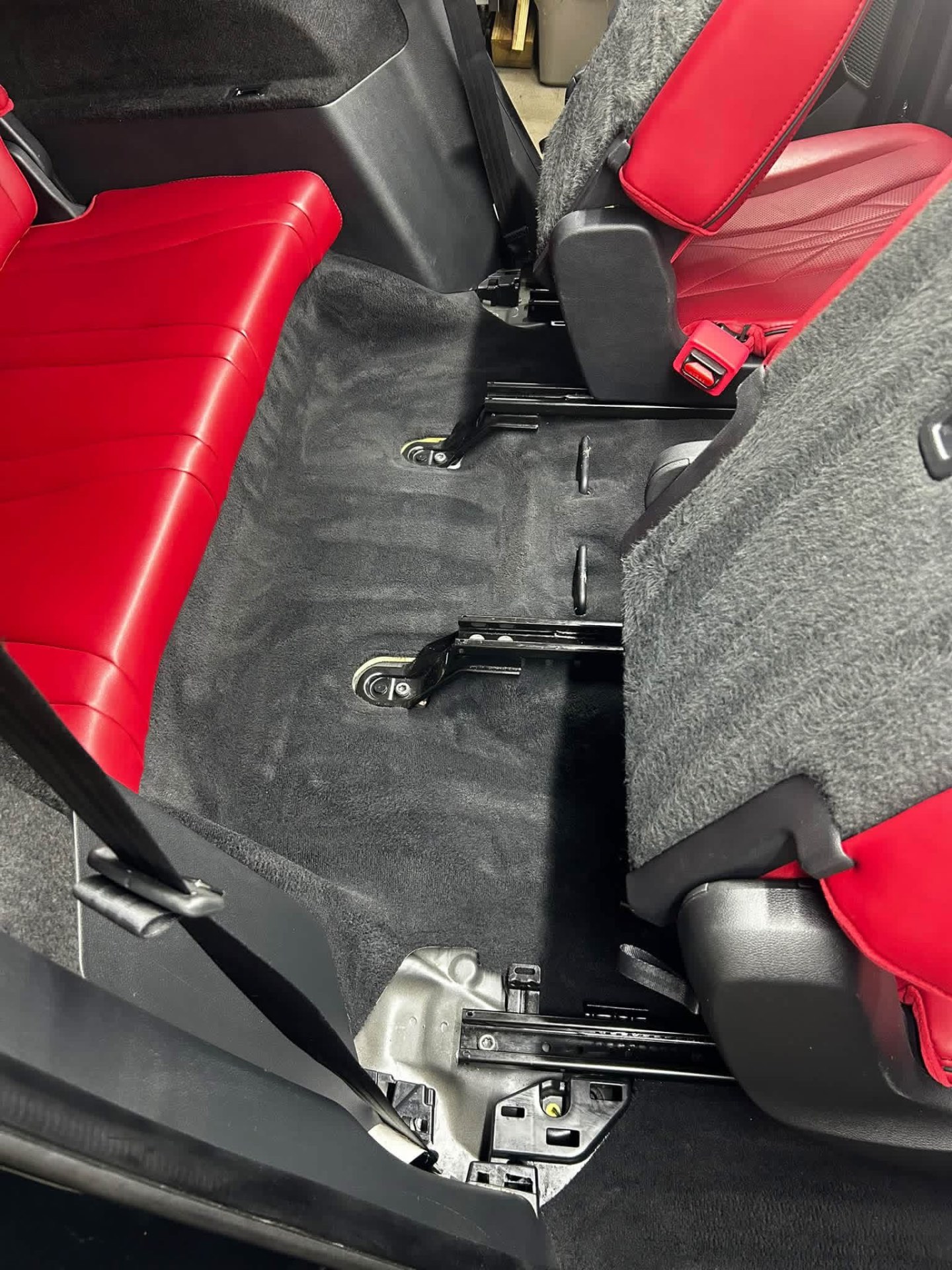 Red leather rear seat and dark cleaned carpet in an Acura